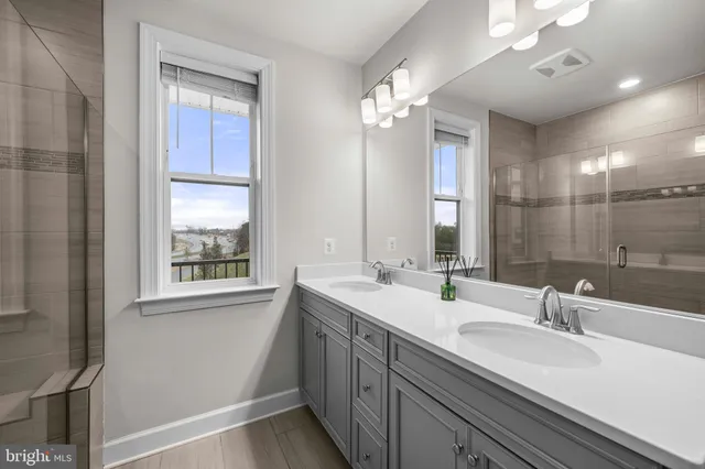 a bathroom with a sink a toilet a mirror a bathtub and shower