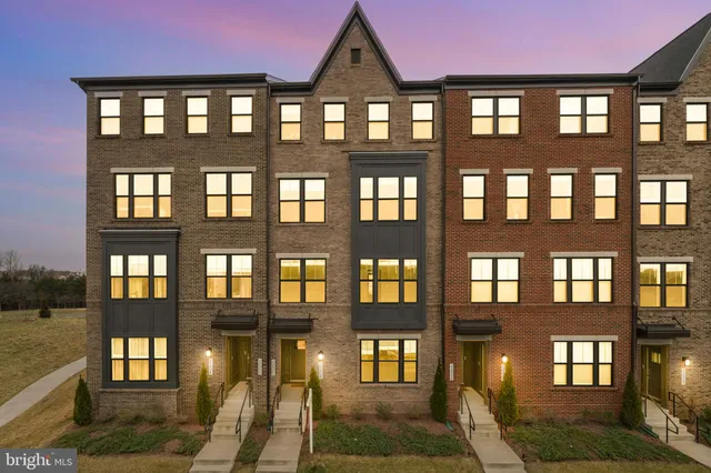 a view of an empty room with wooden floor and a ceiling fan