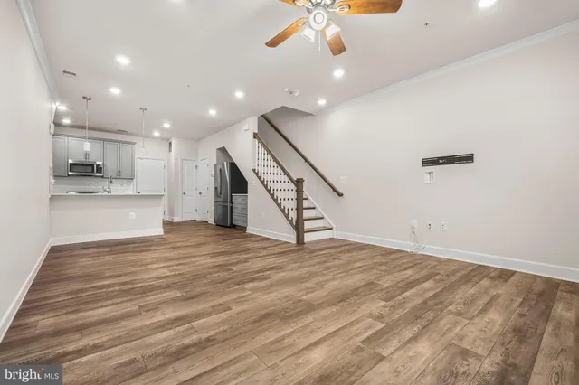 a view of an empty room with a window and a ceiling fan
