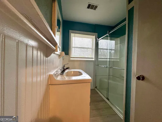 a bathroom with a sink a window and shower