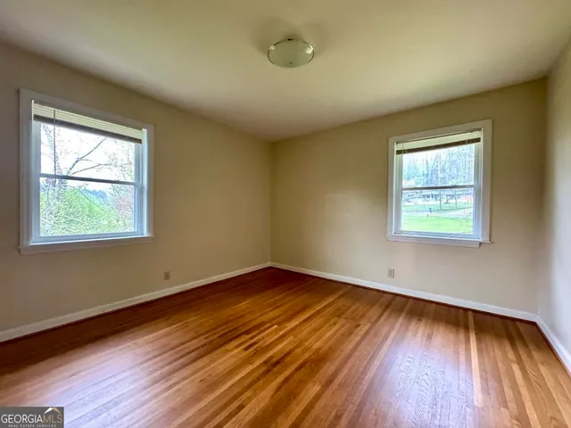 a view of empty room with wooden floor and fireplace