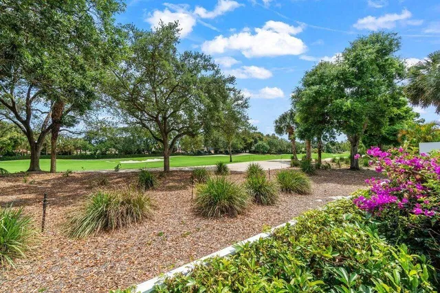 a front view of a house with a yard and potted plants