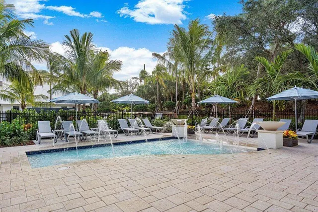 a front view of a residential apartment building with a yard and potted plants