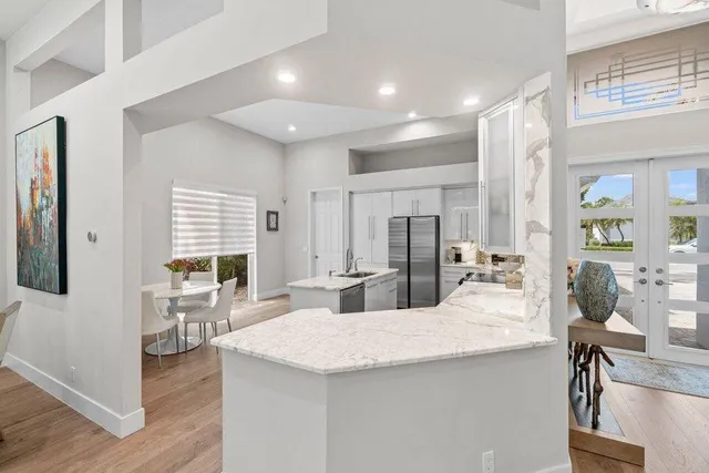 a kitchen with a sink a stove a refrigerator and white cabinets