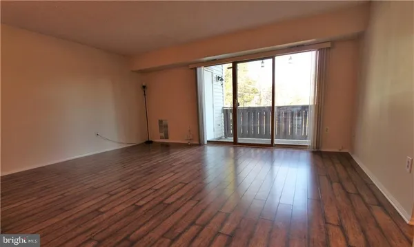 a view of a room with wooden floor and large window