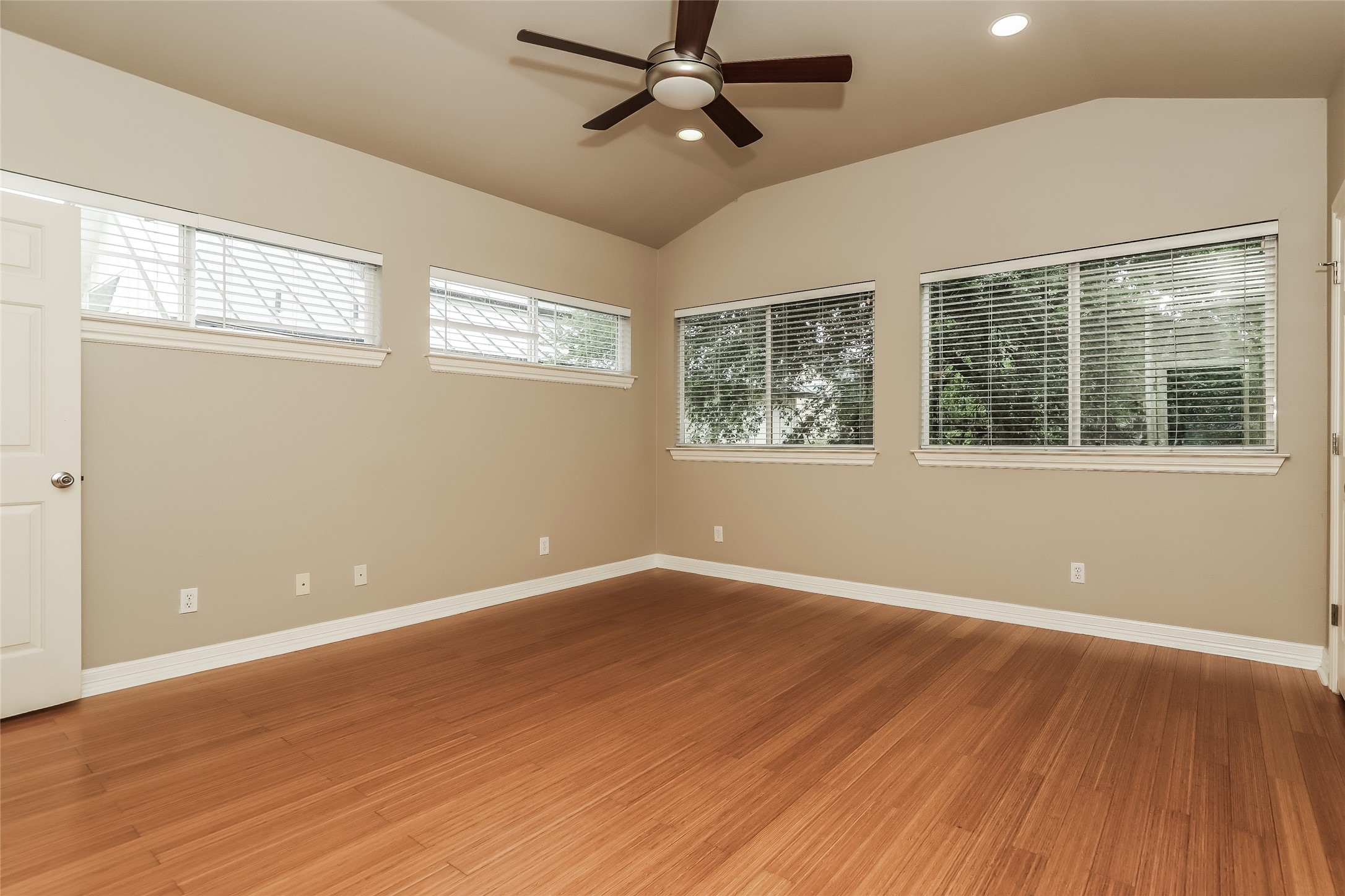 1701 Sanchez Street, Unit A Austin, TX 78702 - Photo 10 of 19 A spacious room features rich wood flooring and a soaring vaulted ceiling with a prominent ceiling fan.