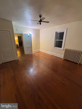a view of a livingroom with wooden floor and a ceiling fan