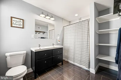 a bathroom with a toilet a sink and mirror