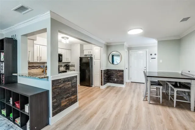 a kitchen with stainless steel appliances kitchen island granite countertop a refrigerator a stove and a wooden cabinets