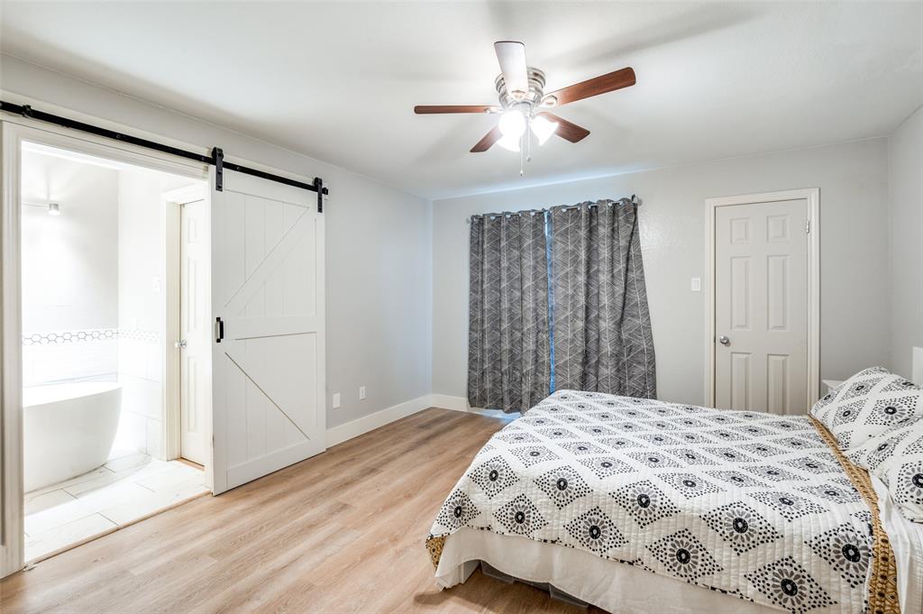 5840 Spring Valley Road, Unit 802 Dallas, TX 75254 - Photo 13 of 26 a bedroom with a large bed and a chandelier