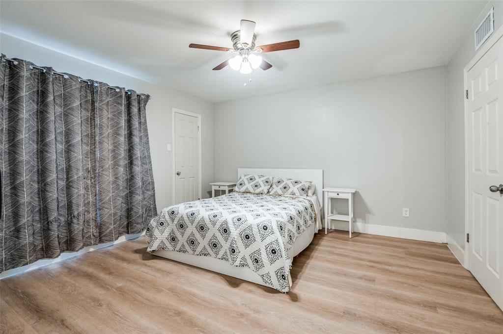 5840 Spring Valley Road, Unit 802 Dallas, TX 75254 - Photo 14 of 26 a bedroom with a bed and a chandelier