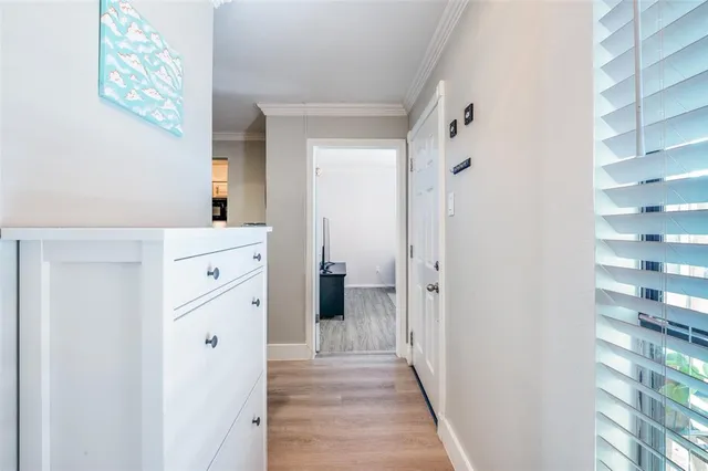 a view of a hallway with closet and wooden floor