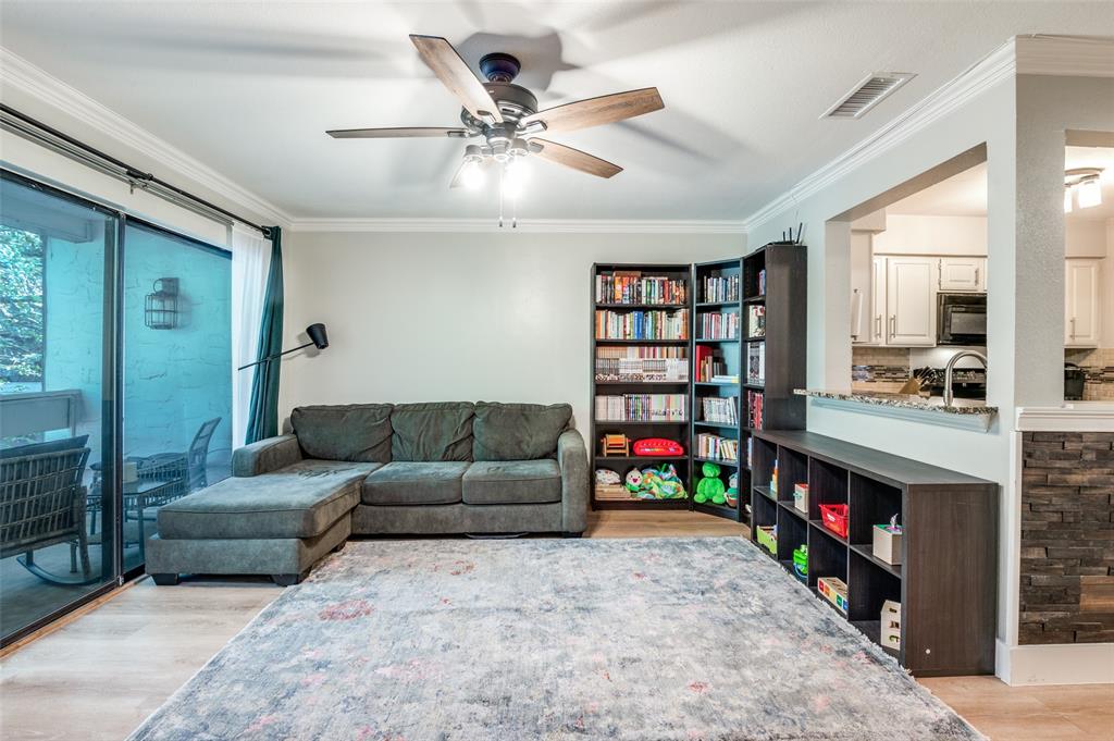 5840 Spring Valley Road, Unit 802 Dallas, TX 75254 - Photo 4 of 26 a living room with furniture and a book shelf
