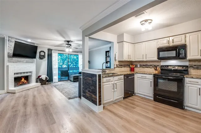 a kitchen with a stove top oven a sink dishwasher a dining table and chairs with wooden floor