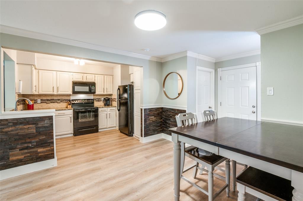 5840 Spring Valley Road, Unit 802 Dallas, TX 75254 - Photo 10 of 26 a kitchen with a table chairs microwave and cabinets