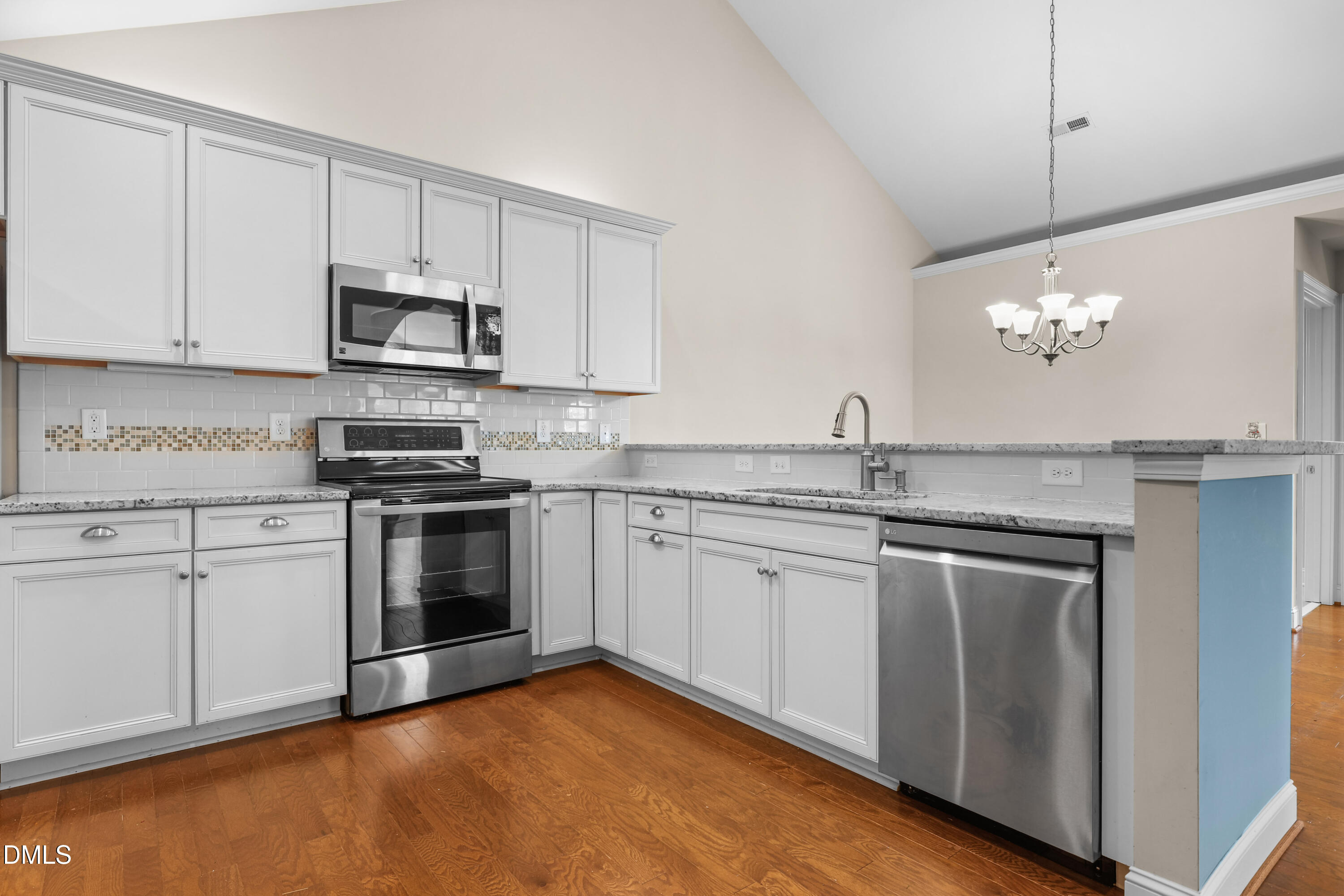1663 Winter Wren Circle Wake Forest, NC 27587 - Photo 9 of 31 a kitchen with stainless steel appliances granite countertop a sink dishwasher a stove and a microwave oven with cabinets