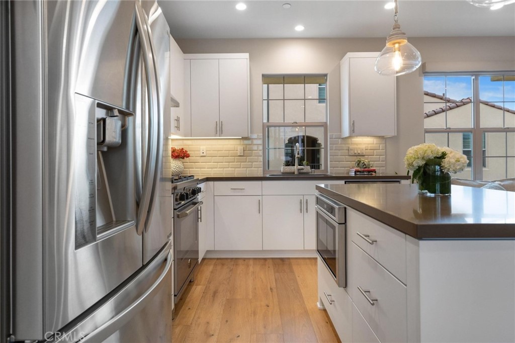 125 Leafy Twig Irvine, CA 92618 - Photo 13 of 35 a kitchen with white cabinets and stainless steel appliances
