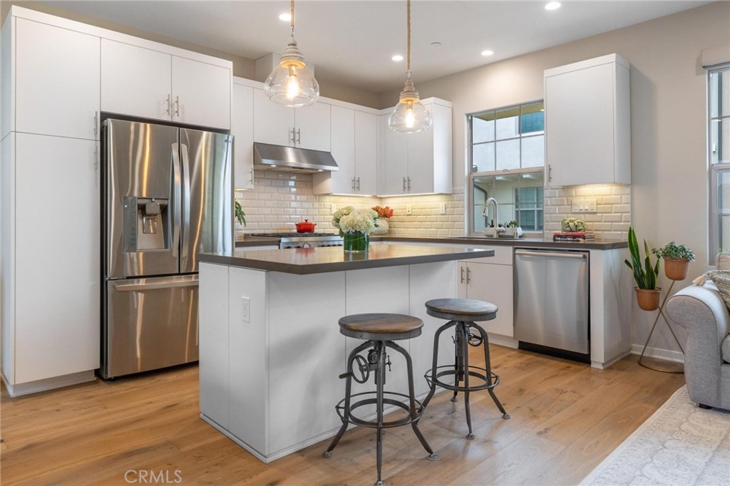 125 Leafy Twig Irvine, CA 92618 - Photo 10 of 35 a kitchen with stainless steel appliances granite countertop a refrigerator a sink dishwasher a stove and a refrigerator with wooden floor