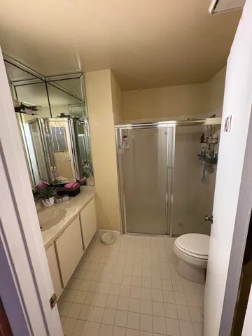 a bathroom with a granite countertop sink a toilet and shower