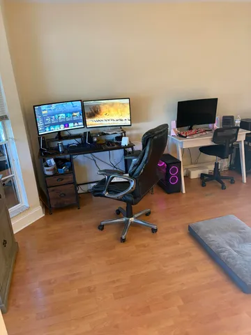 a view of a workspace with furniture and a window