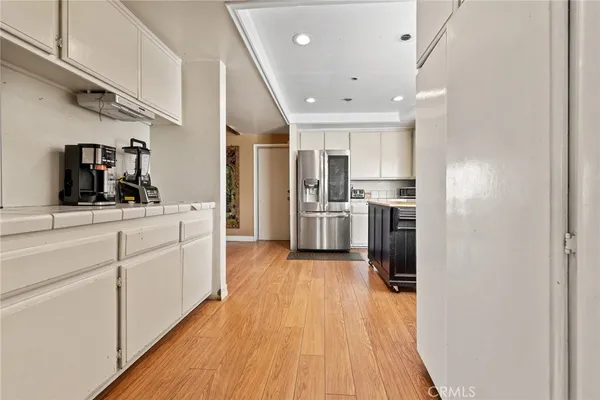 a kitchen with stainless steel appliances kitchen island granite countertop a refrigerator and a sink