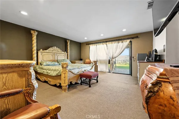 a bedroom with furniture and large windows