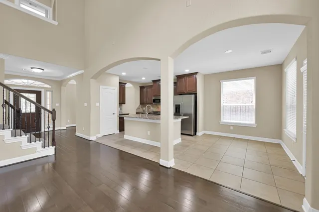 a view of a kitchen with refrigerator and wooden floor
