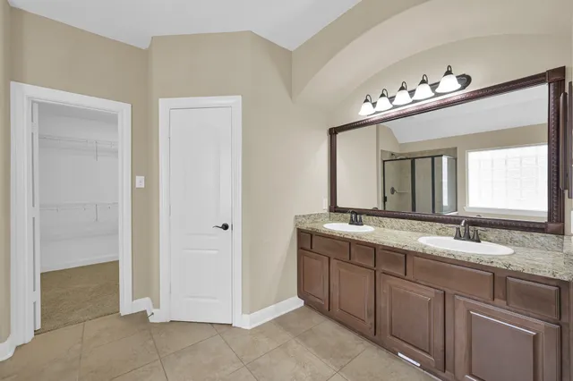 a bathroom with a double vanity sink and a mirror