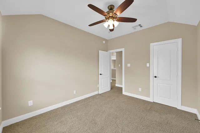 an empty room with a chandelier fan and a ceiling fan