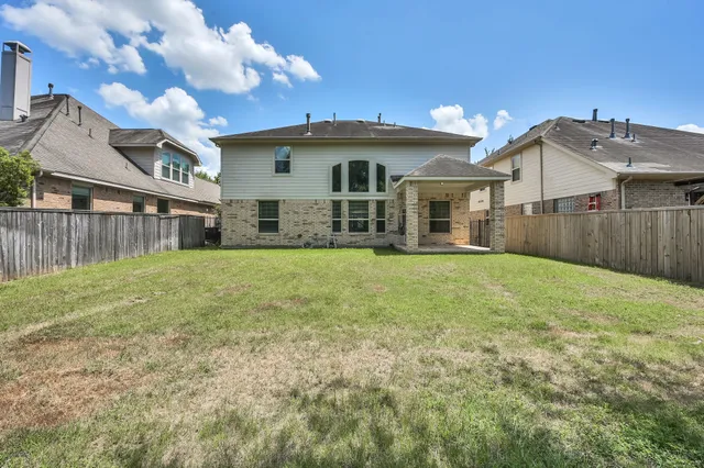 a view of a house with a big yard and large tree