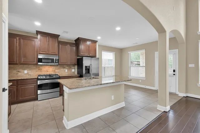 a kitchen with stainless steel appliances granite countertop a stove sink and cabinets