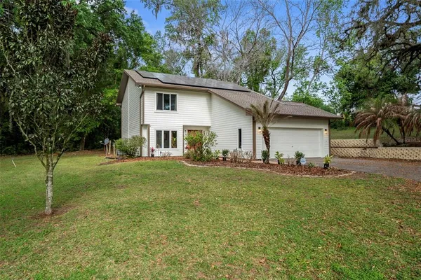 a view of a house with backyard and a tree