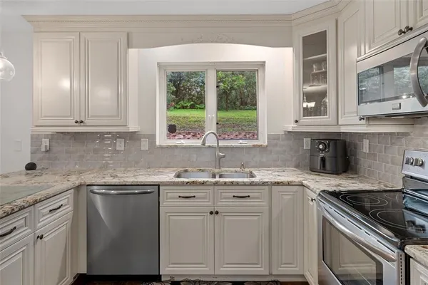 a kitchen with white cabinets and refrigerator