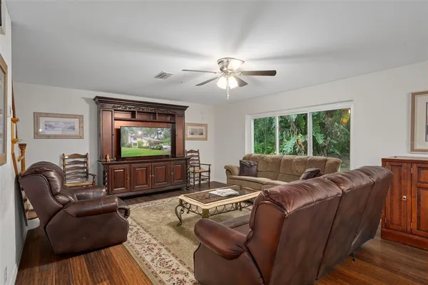 a living room with furniture ceiling fan and a rug