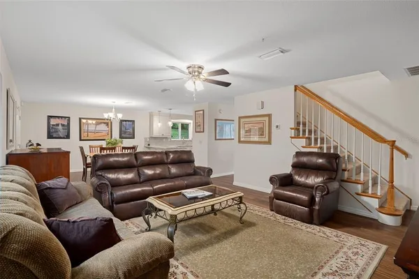 a living room with furniture ceiling fan and a large window