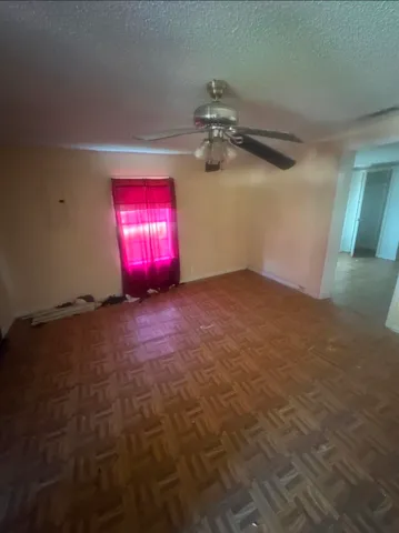 en empty room with windows and fan