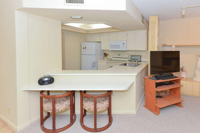 1605 Highway 1, Unit C203 Jupiter, FL 33477 - Photo 11 of 31 a kitchen with stainless steel appliances a stove a microwave and cabinets