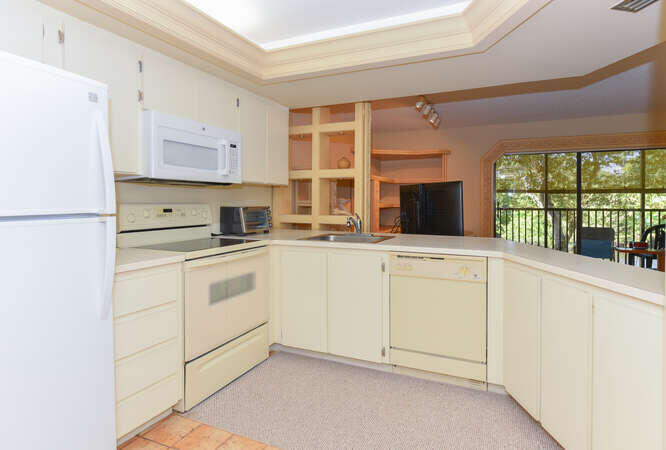 1605 Highway 1, Unit C203 Jupiter, FL 33477 - Photo 15 of 31 a kitchen with white cabinets and white appliances