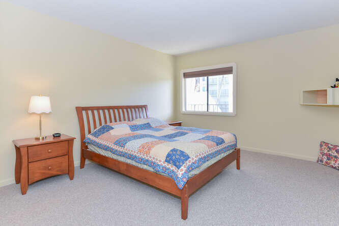 1605 Highway 1, Unit C203 Jupiter, FL 33477 - Photo 19 of 31 a bedroom with a bed lamp and a window
