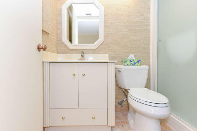 1605 Highway 1, Unit C203 Jupiter, FL 33477 - Photo 20 of 31 a bathroom with a toilet a sink a mirror and vanity