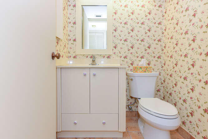 1605 Highway 1, Unit C203 Jupiter, FL 33477 - Photo 22 of 31 a bathroom with a toilet a sink a vanity and mirror