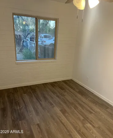 a view of a room has wooden floor and a window