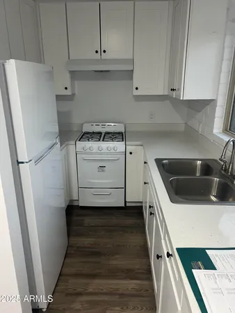 a kitchen with a white stove top oven and sink