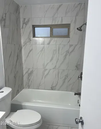 a bathroom with a toilet and a bath tub