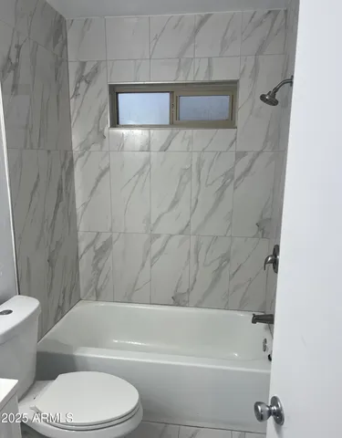 a bathroom with a toilet and a bath tub