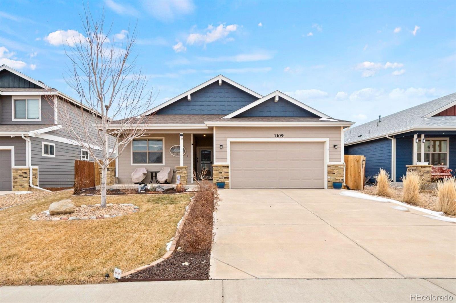 1109 Bison Way Wiggins, CO 80654 - Photo 2 of 33 a front view of a house with yard slide and large tree