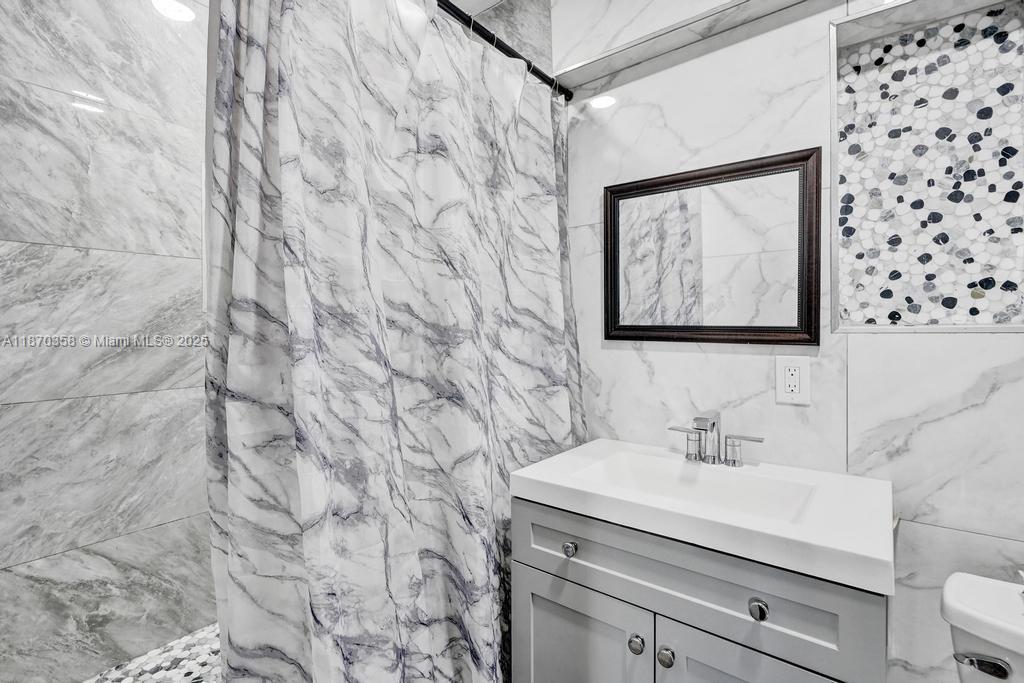 900 Crystal Lake Drive, Unit 2B Deerfield Beach, FL 33073 - Photo 18 of 41 a bathroom with a sink and a mirror