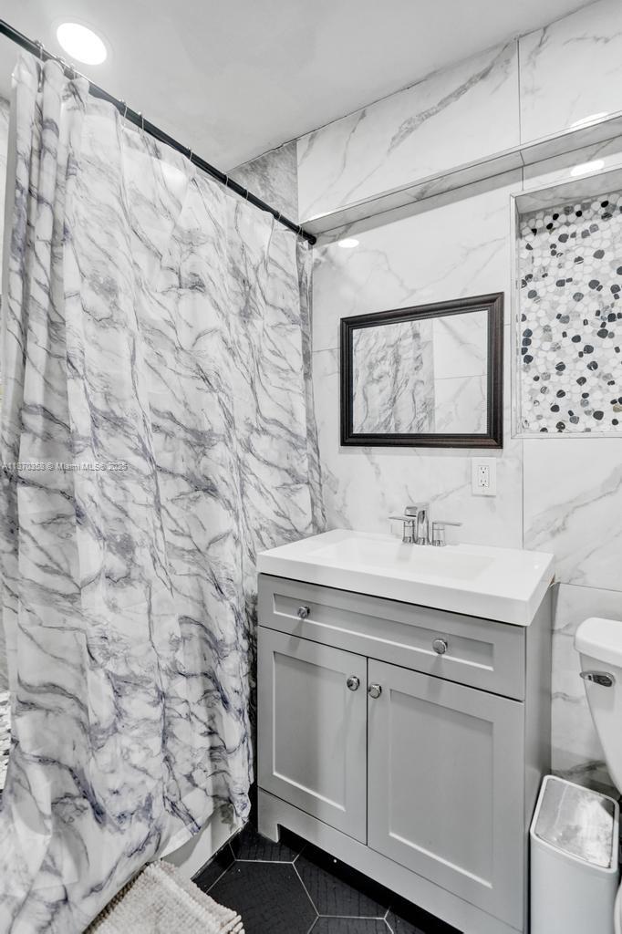 900 Crystal Lake Drive, Unit 2B Deerfield Beach, FL 33073 - Photo 19 of 41 a bathroom with a granite countertop sink and a toilet
