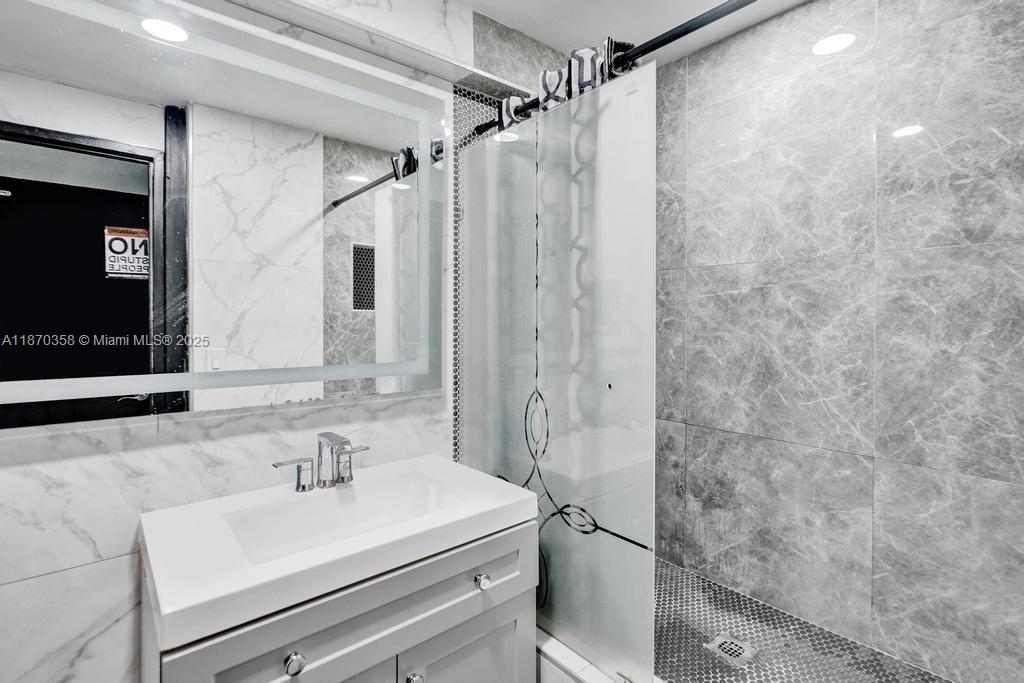 900 Crystal Lake Drive, Unit 2B Deerfield Beach, FL 33073 - Photo 20 of 41 a bathroom with a sink vanity granite and a mirror