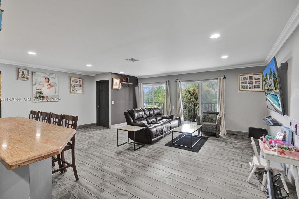 900 Crystal Lake Drive, Unit 2B Deerfield Beach, FL 33073 - Photo 2 of 41 a living room with furniture and a flat screen tv